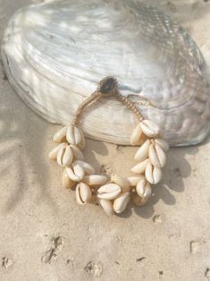 Introducing our new beach accessory: the OCEAN COWRIE SEASHELL BRACELET. Crafted with natural shells sourced from the depths of the ocean in Thailand, this statement piece beautifully captures the essence of the sea. Each shell is carefully combined to create a captivating and unique representation of oceanic beauty. Perfect for beach outfits, honeymoons, resort wear, or gift for your love ones, this choker necklace is a versatile addition to your wardrobe. What sets it apart is our commitment t Vacation Shell Beaded Bracelets, White Bohemian Shell Bracelet, Beachy Shell Bracelet Jewelry, Cowrie Shell Beaded Bracelets As Gift, Shell Jewelry Bracelet For Vacation, Shell Bracelet Jewelry For Vacation, Beaded Shell Strand Bracelets, Shell Bracelet For Beach, Adjustable Shell Bracelets With Ocean-inspired Style