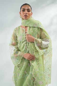 a woman wearing a green dress and shawl