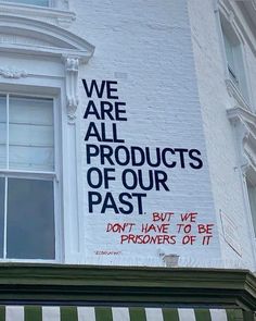 a sign on the side of a building that says we are all products of our past