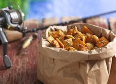 a brown paper bag filled with food next to a fishing rod