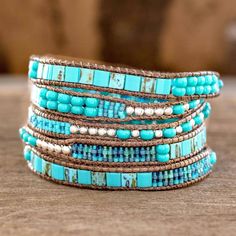 The contrast between blue and turquoise with silvery colored beads inspires soothing elegance. Women artisans from Guatemala's Weaving Hands of Atitlan craft the wrap bracelet by hand with dark brown cords. Adjustable Blue Artisan Beaded Bracelets, Adjustable Artisan Blue Beaded Bracelets, Blue Artisan Adjustable Beaded Bracelet, Blue Spiritual Wrap Bracelet With Gemstone Beads, Spiritual Blue Gemstone Beads Wrap Bracelet, Spiritual Blue Wrap Bracelet With Gemstone Beads, Spiritual Beaded Turquoise Wrap Bracelet, Blue Bohemian Bracelets For Meditation, Blue Bohemian Beaded Bracelets For Meditation