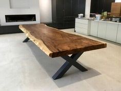 a large wooden table sitting in the middle of a room next to a fire place