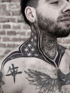 a man with lots of tattoos on his chest and neck is looking to the side