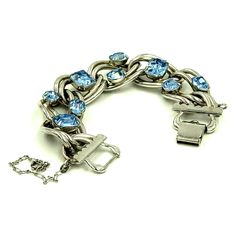 Vintage 50's chunky blue rhinestone silver tone double link bracelet.  Unsigned. Measures approx. 7.5 inches long and .75 inches wide Prong set rectangular and oval cut light blue rhinestones are set at intervals on heavy silver tone chain Fold over clasp Safety chain with spring ring closure Slight surface scratching consistent with age and gentle use.  Rhinestones sparkle and shine!   Interesting mid century piece.  High end construction. Geometric Bracelet, Gems Bracelet, Wedding Jewelry Bracelets, Safety Chain, Blue Gems, Rhinestone Bracelet, Blue Rhinestones, Bracelet Silver, Blue Bracelet