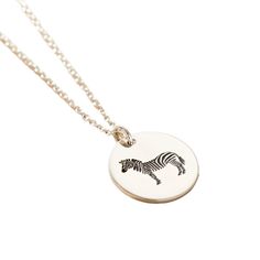 This unique Zebra Spirit Animal Necklace is made in our Brighton workshop. Crafted from 925 sterling silver the pendant is engraved with an intricate Zebra design. Zebra’s are are unique, bold, beautiful, quick witted, resourceful, and adaptable. The disc is suspended from a fine trace chain necklace. This necklace makes the perfect birthday gift for someone special. The necklace is handmade in sterling silver. Pendant measures 1. 6mm across. Comes suspended on 18" fine chain. Handmade in 925 Sterling Silver Etched Sterling Silver Necklaces, Silver Etched Sterling Silver Necklace, Symbolic Sterling Silver Engraved Charm Necklaces, Sterling Silver Etched Necklace For Gift, Etched Sterling Silver Pendant Necklace, Etched Sterling Silver Necklace For Gift, Etched Sterling Silver Necklace Gift, Etched Sterling Silver Round Necklace, Stamped Sterling Silver Pendant Jewelry