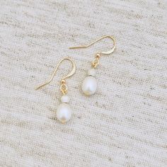 Gold plated white natural freshwater pearl drop earrings alongside a sterling silver stardust bead. Beautifully simple! Gold plated, beautiful white natural potato shaped small freshwater pearl drop earrings. The wire through the pearl itself is gold plated as well as the earring hook. Drop length is approx 1.2/1.3cm as these are natural pearls each pair will differ slightly in drop length and look due to the nature of natural pearls. Please watch the video which shows how beautifully these pear Adjustable Dainty Pearl Earrings, Everyday White Pearl Pendant Earrings, Everyday Hypoallergenic Pearl White Pearl Earrings, Delicate Adjustable Pearl Earrings With Ear Wire, Delicate Pearl Hypoallergenic Earrings, Dainty Pearl White Earrings, Delicate White Pearl Earrings For Everyday, Dainty Adjustable Dangle Pearl Earrings, Minimalist White Earrings With Pearl Pendant