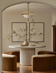 a dining room table with two chairs and a vase on it