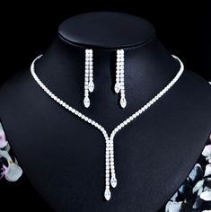 An elegant two-piece bridal jewelry set with a lariat-style necklace and drop earrings. Adorned with intricately faceted cubic zirconia that capture the light from every angle with a perfectly translucent appeal, the pieces are platinum plated for a flawless finish which enhances the intricate detailing and conveys a modern take on old elegance. Necklace: 17" (approx. 43cm) long with a secure fold-over closure. If longer is needed please leave a note at checkout with the desired length. The doub Lariat Style Necklace, Bride Jewelry Set, Jewellery Bridal, Jewelry Set Design, Bridal Necklace Set, Silver Wedding Jewelry, Wedding Party Gift, Wedding Bridal Jewellery, Fashion Jewelry Sets