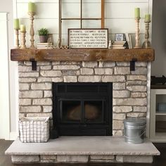 a stone fireplace with candles and other items on top of the mantel above it