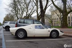 a white sports car parked in a parking lot