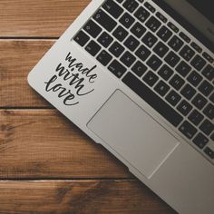 an open laptop computer sitting on top of a wooden table next to a cup of coffee