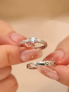 two women's hands holding wedding rings with diamonds on each one and the other hand