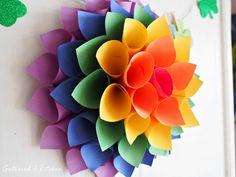 a colorful paper flower hanging from the side of a wall