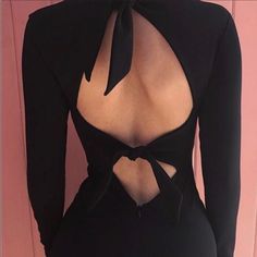 the back of a woman's black bodysuit with cutouts and a bow tie