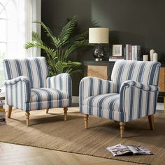 a living room with two striped chairs and a rug in front of the couches