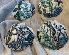 four blue and white beaded buttons sitting on top of a cloth