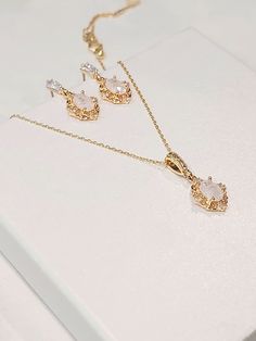 High quality champagne gold plated crystal earrings and necklace set with beautiful frosted white cubic zirconia stones. The chain is 1mm thick and 46cm long. It is easily adjustable to make it shorter to your desired length simply by pulling on the chain through the round gold bead. It also has 2 removal options - using the clasp or pulling the chain out of the round gold bead as shown in the pictures. There are 2 jewelry box options: Box A: regular jewelry cardboard box with a textured diamond pattern on the outside (comes in white, black or red) Box B: Velvet earring and necklace box (comes in green, red and grey) You can also add a mini gift bag as show in the pics: comes with green, red or grey satin ribbon and a few sheets of gift tissue paper. Ready to ship in 1-3 business days Come Elegant Jewelry With Matching Earrings And Oval Pendant, Gold Oval Jewelry Set For Wedding, Oval Gold Jewelry Set For Wedding, Oval Pendant Jewelry Set As Gift, Oval Crystal Earrings Gift, Oval Crystal Earrings For Gifts, Elegant Oval Jewelry Sets As Gifts, Elegant Oval Jewelry Set For Gift, Gatsby Earrings