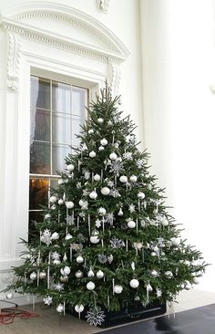 a decorated christmas tree sitting in front of a window