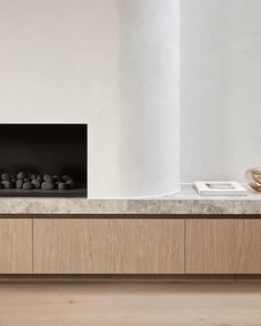 a modern fireplace with rocks on the mantle