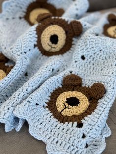 two crocheted teddy bears are laying on top of a blanket that is folded over