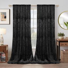 black velvet curtains hanging on a wall in a living room with a mirror and table