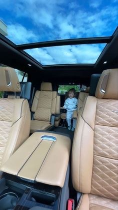 a little boy standing in the back seat of a car