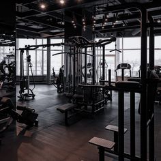 an empty gym with lots of machines and equipment in the room, all lit up by bright lights