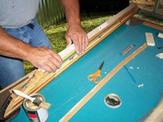 a man is working on an art project with scissors, tape and other items around him