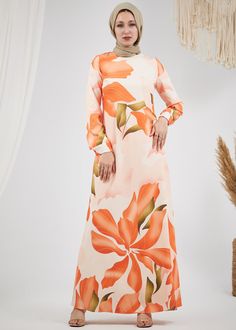 Step into elegance with our Radiant Floral Satin Maxi Dress. This stunning piece features a captivating floral pattern in vibrant hues of orange and green, making it a perfect choice for any special occasion. Crafted from luxurious satin, the dress is fully lined for comfort and modesty. The design includes long, subtly flared sleeves and a chic high neck, adding a touch of sophistication to your look. The dress is beautifully tailored with a matching belt that cinches the waist, creating a flat Orange Long-sleeved Maxi Dress For Garden Party, Orange Long Sleeve Maxi Dress For Garden Party, Elegant Orange Printed Maxi Dress, Orange Long Sleeve Printed Maxi Dress, Peach Floral Print Long Sleeve Dresses, Peach Long Sleeve Floral Print Dress, Orange Floral Print Maxi Dress For Garden Party, Orange Floral Maxi Dress For Garden Party, Elegant Orange Maxi Dress For Garden Party