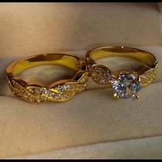 two gold wedding rings sitting on top of each other