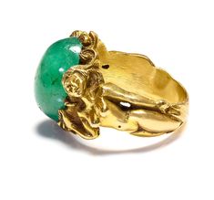 Antique Gold Large Cabochon Emerald Nude Lady Ring Dive into the enchanting realm of Art Nouveau with this magnificent gold ring, a testament to exquisite craftsmanship and artistic vision. This piece features a delicate assembly of sculpted ladies, each figure intertwined gracefully, representing the period's fascination with fluid, natural forms. At the center of this collective beauty sits a striking cabochon emerald, its lush green depths echoing the vibrant life of untouched nature. This si Antique Gold Emerald Ring With Oval Cabochon, Antique Emerald Ring In Gold With Oval Cabochon, Gold Art Nouveau Jewelry With Intaglio, Art Nouveau Yellow Gold Collectible Rings, Antique Gold Emerald Cabochon Ring, Collectible Art Nouveau Yellow Gold Ring, Art Nouveau Gold Ring With Gemstone, Art Nouveau Yellow Gold Intaglio Jewelry, Art Nouveau Yellow Gold Ring