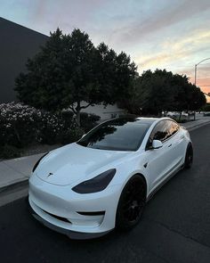 a white car is parked on the side of the road