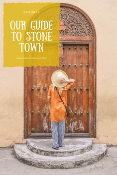 a woman standing in front of a door with the words our guide to stone town