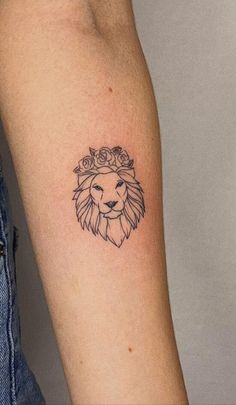 a small lion tattoo on the arm