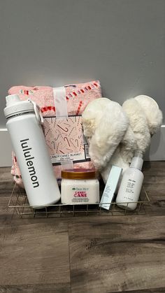 a white teddy bear sitting on top of a wooden floor next to bottles and other items