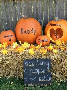 pumpkins with names carved into them sitting on hay bales in front of a fence