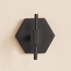 a black hexagonal hook on the wall