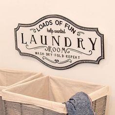 a laundry room sign hanging on the wall next to a baby's crib