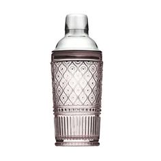 a clear glass bottle with a brown lid and an intricate design on the top, sitting in front of a white background