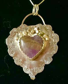 "Remember your love with this charming, sentimental gift of sterling silver.  Completely hand fabricated and stamped, this delightful piece also features a genuine purple agate stone and a sterling blossom with dewdrops. Measures 1 3/4 x 1 3/4 inches. 18\" sterling chain included." Silver Amethyst Jewelry With Heart Charm, Amethyst Heart Pendant Jewelry For Anniversary, Handmade Heart Pendant Jewelry Keepsake, Handmade Heart Pendant Jewelry For Keepsake, Artisan Heart-shaped Jewelry For Anniversary, Unique Handmade Open Heart Jewelry, Artisan Sterling Silver Purple Jewelry, Heart-shaped Agate Jewelry With Natural Stones, Purple Artisan Sterling Silver Jewelry