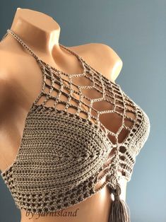 a mannequin wearing a crocheted top with tassels on it