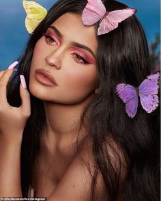 a woman with long black hair and three butterflies on her head is posing for the camera