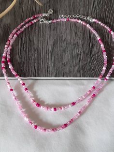 a necklace with pink beads on a wooden table