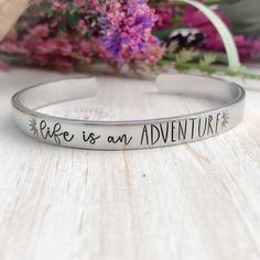 Life is an adventure. Made from 6" aluminum. These cuffs are lightweight and can easily be worn with other bracelets. Available in 3/8" and 1/2" widths.Custom orders and sayings welcome!Looking for something else? Check out my other listings!https://www.etsy.com/shop/StampinStitchin?ref=seller-platform-mcnavTO WEAR:Slide sideways over the thinnest part of your arm, and turn so the opening is at the bottom of your wrist. While these will bend a bit to fit a variety of wrists, once it is the corre Hand Stamped Cuff Bracelet, Mantra Bracelet, Boho Chic Bracelets, Metal Stamped Jewelry, Senior Gifts, Spoon Rings, Name Bracelet, Cute Bracelets, Stamped Jewelry