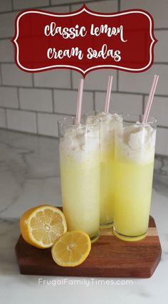 two glasses filled with ice cream and lemons on top of a cutting board next to sliced oranges