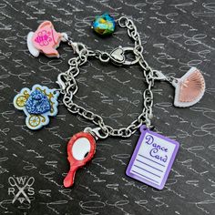 Introducing Bestie Charm Club! Get ready to add some charm to your life with our playful and colorful charms. Perfect for collecting and adding a special touch to your outfit. Reminisce about the 80's with our exclusive charms on a charm bracelet or necklace. Join the club now! This bracelet includes a special edition Czech Crystal embellishment and all 5 charms in the Spill the Tea Collection: -Teapot -Hand Mirror -Hand Fan -Dance Card -Royal Carriage Tell your story and show what you love thro Novelty Multicolor Charm Bracelet, Friendship Novelty Charm Bracelet, Adjustable Novelty Charm Bracelet, Pink Novelty Bracelets With Charms, Pink Charms Bracelets Novelty Style, Fun Charms Bracelets For Birthday, Fun Charm Bracelets For Birthday, Fun Birthday Charms Bracelets, Playful Nickel-free Charm Bracelet For Gift