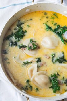 a pot filled with dumplings and broccoli on top of a white towel