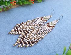 a pair of beaded earrings sitting on top of a blue surface