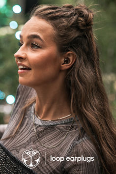 a woman with long hair standing in front of a christmas tree and looking off to the side