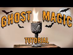 a candle that is on top of a table with the words ghost magic in front of it